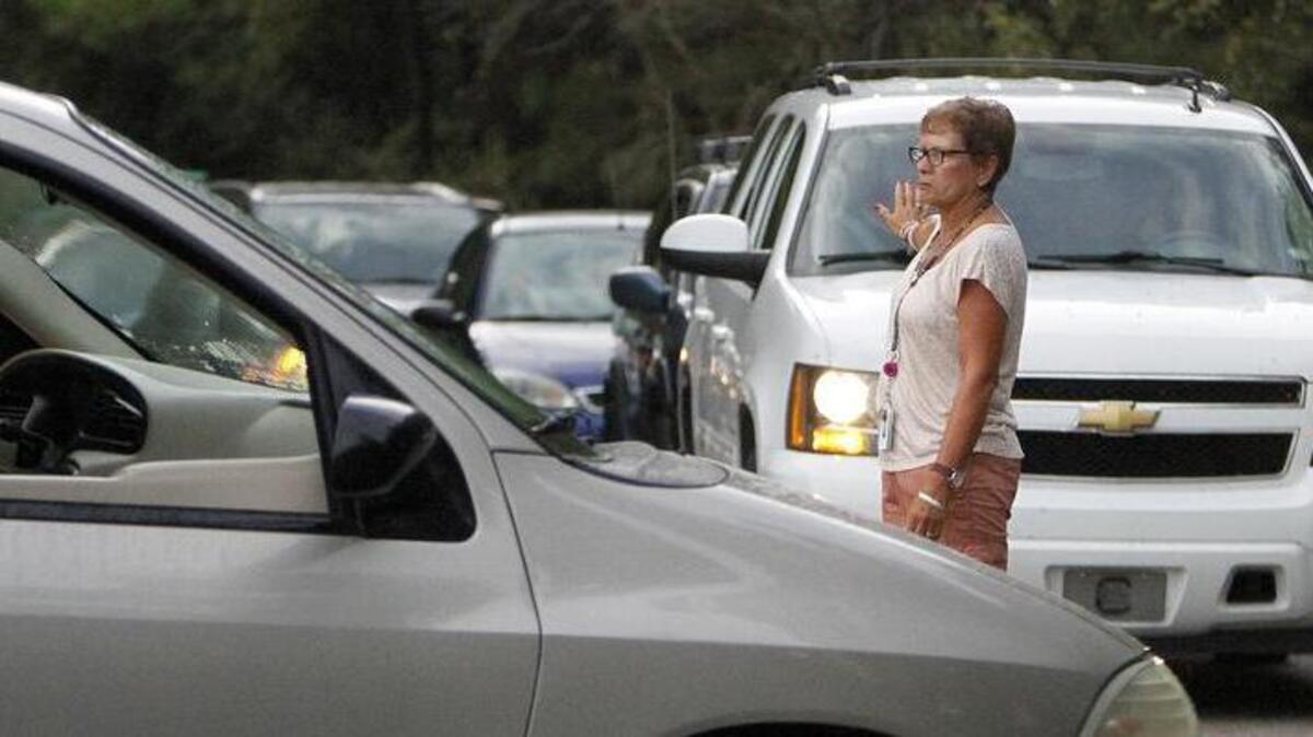 
Parents follow the staff waves and signs as they make their way around the new traffic loop at Seaside Elementary School on Thursday. The loop circles the school in the Garden City Beach area. It is designed to alleviate traffic issues on U.S. 17 business at Woodland Drive.
