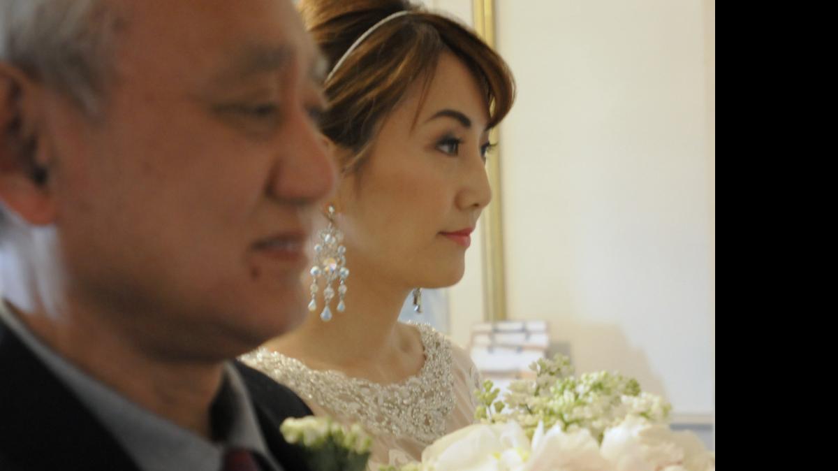 
Xuan Zhuang looks into the sanctuary of the old First Presbyterian Church as she waits to walk down the aisle and marry Dan Liu Tuesday morning.

