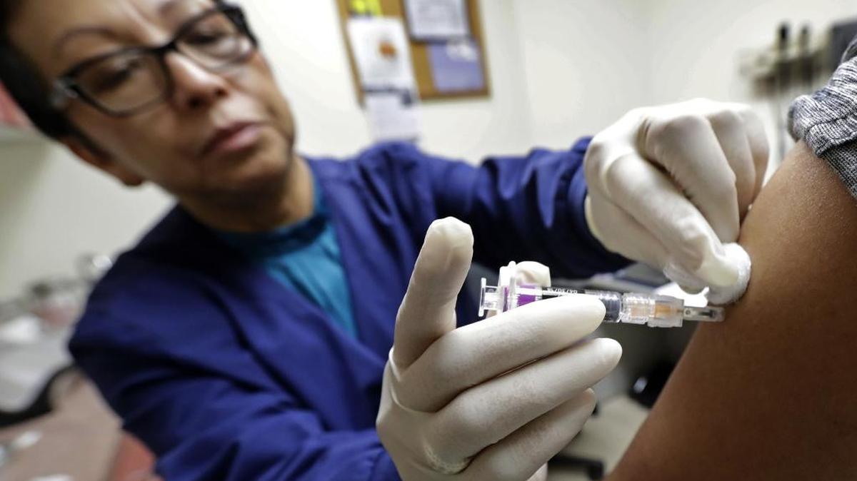 Ana Martinez, a medical assistant at the Sea Mar Community Health Center, gives a patient a flu shot in Seattle.