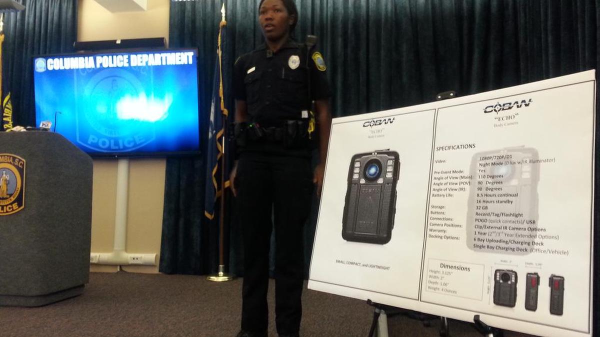Officer Monica Parker demonstrates one of the new body-worn cameras Columbia police will be rolling out next year.