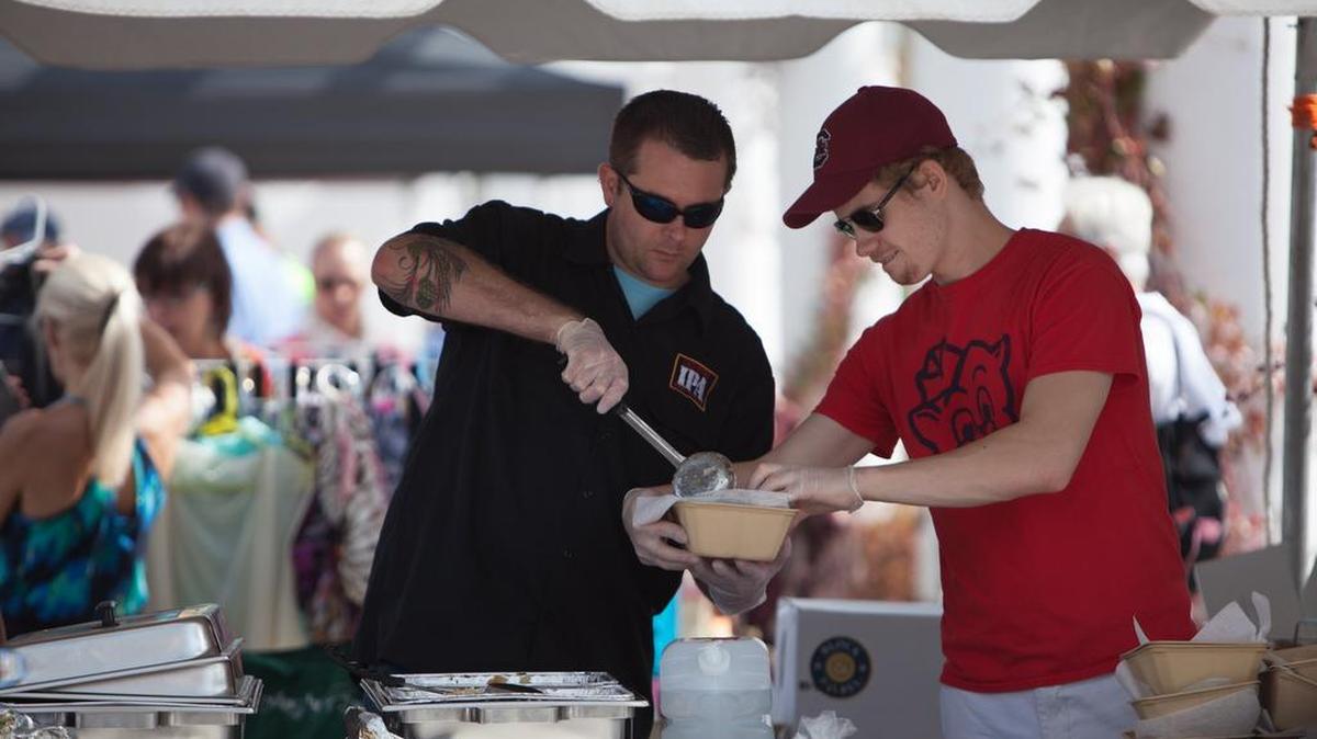 Piggly Wiggly store manager Mike Byrd, left, and employee Mike Wodel plate sauerbraten wit spaetzel and bratwurst with sauerkraut during Oktoberfest 2015 in Valor Park at the Market Common. The only supermarket within The Market Common will be closing.