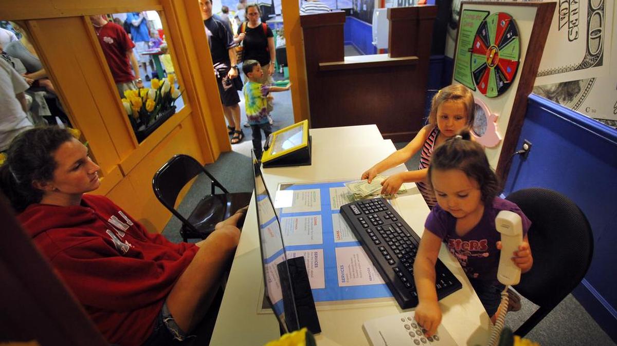 Family members play in a “Big Bank” exhibit at the Children’s Museum of South Carolina, in Myrtle Beach. As of March 1, the site will merge operations with EdVenture, a children’s museum in Columbia.