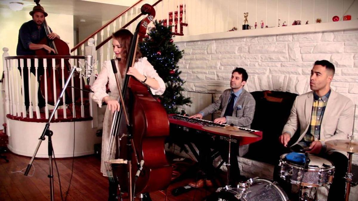 The group Post Modern Jukebox, featuring Kate Davis on vocals and acoustic bass, performs “Blue Christmas” in a music video.