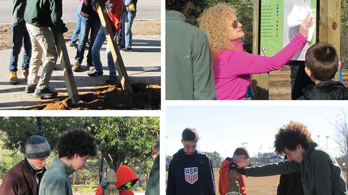 Members of Boy Scout Troop 801work to place signs and kiosks along Market Common trials.
