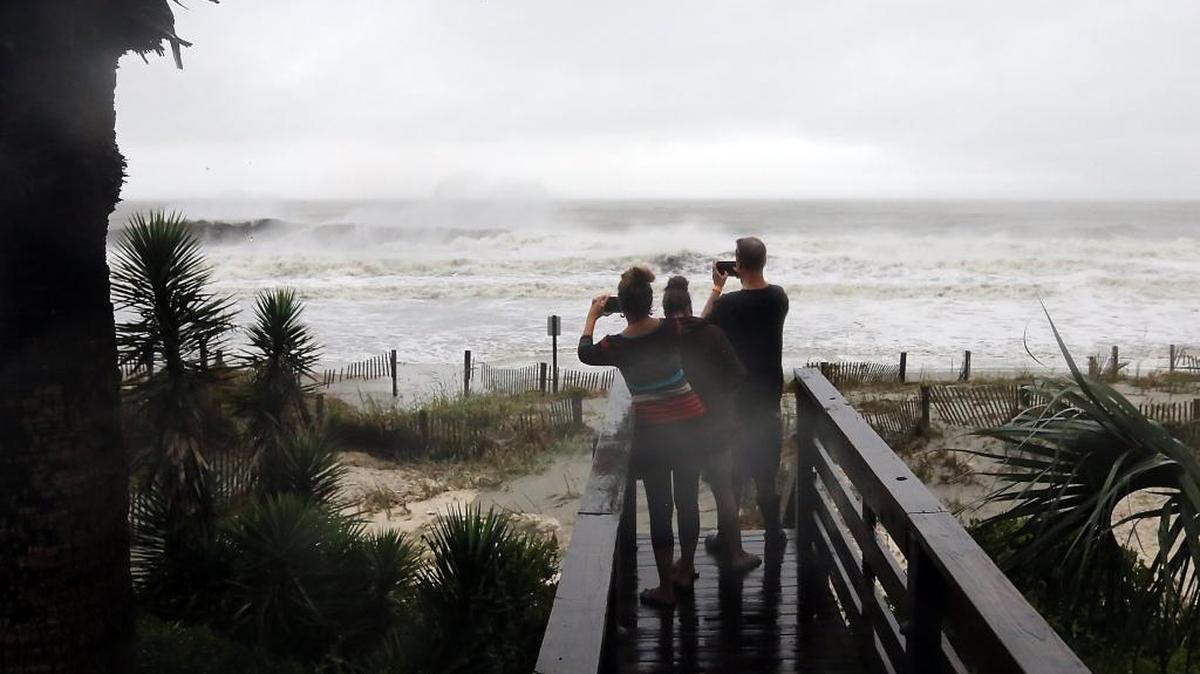 People watch as about 50-feet of Surfside Beach pier is snapped off on Saturday, Oct. 8, 2016, as Hurricane Matthew goes north.