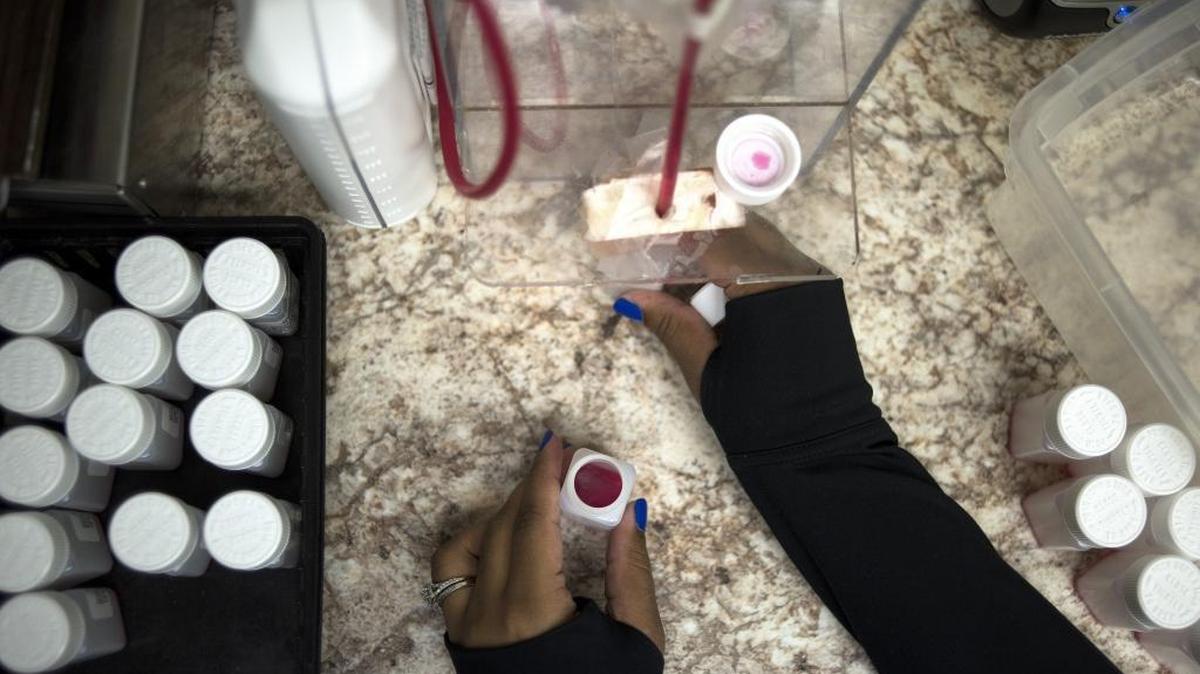 A nurse fills bottles with small amounts of liquid methadone for take-home prescriptions at a clinic in the Community Health Center in Akron, Ohio, Dec. 18, 2017.