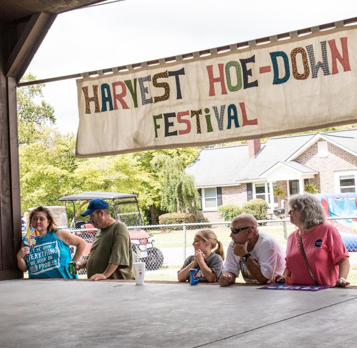 Festivalgoers find respite from the heat in the shade behind the main stage. The Annual Harvest Hoedown Festival in Aynor welcomes people from around the region Saturday, September 17, 2016.