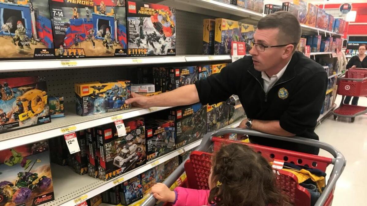 Myrtle Beach Fire Lt. Jonathan Evans gets a little help from his daughter, Lilly, while shopping for Christmas items for local children on Thursday.