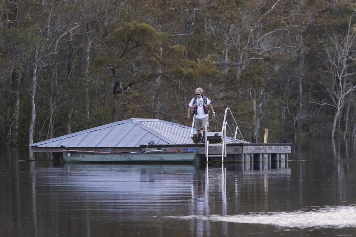 A man check looks at his flooded boat house from a floating dock on the Waccamaw River near Bucksport. The Waccamaw River at Conway crested Wednesday at well over 21 feet flooding many downtown homes. Wednesday, Sept. 26, 2018.