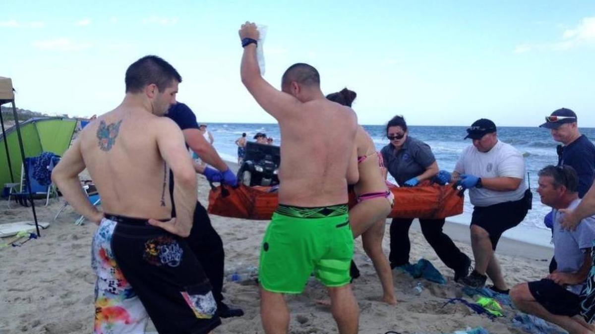 
Emergency responders assist a teenage girl at the scene of a shark attack in Oak Island, N.C., on Sunday. Mayor Betty Wallace of Oak Island, a seaside town bordered to the south by the Atlantic Ocean, said that hours after the teenage girl suffered severe injuries in a shark attack Sunday a teenage boy was also severely injured. (Steve Bouser/The Pilot, Southern Pines, N.C. via AP) | Steve Bouser The Associated Press
