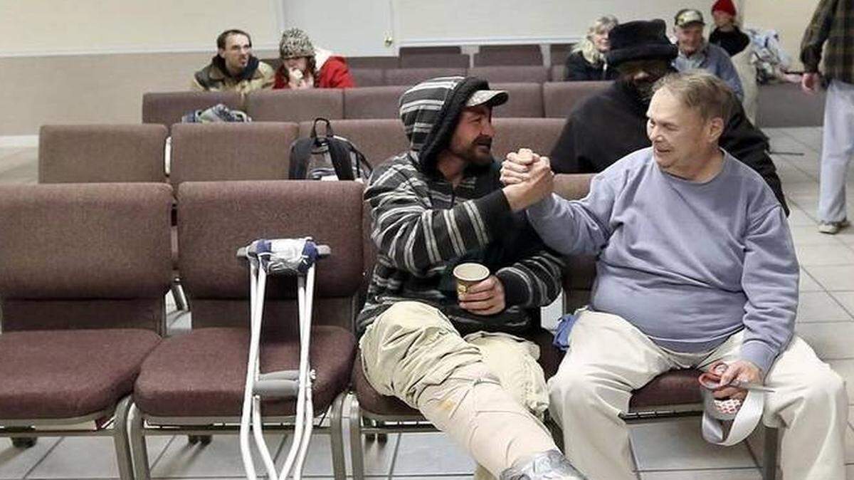 
"You're a good man, George. George is ducking it. As long as I got George, I'm all right," Eric Martin (left) said watching volunteer George Lorenz wrapping his broken foot with duct tape at Sun Coast Christian Church Emergency Shelter in Myrtle Beach on Wednesday, Jan. 28, 2015. Martin was hit by a car on U.S. 501 and broke his ankle. About 30 people gather at the emergency shelter for a warm meal and a place to sleep inside the church as the temperatures outside drop. Photo by Janet Blackmon Morgan / jblackmon@thesunnews.com

