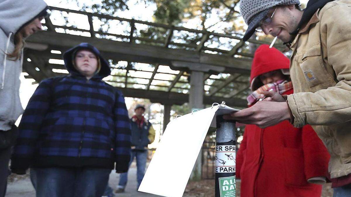 
About 30 people sign the rules before being taken to Sun Coast Christian Church Emergency Shelter in Myrtle Beach on Wednesday, Jan. 28, 2015. The rules include being respectful, no alcohol, no drugs no weapons and smoking in the designated outside of the church building. The pickup is made at Chapin Park. Once at the church, the people are given a warm meal and a place to sleep inside the church as the temperatures outside drop. Photo by Janet Blackmon Morgan / jblackmon@thesunnews.com

