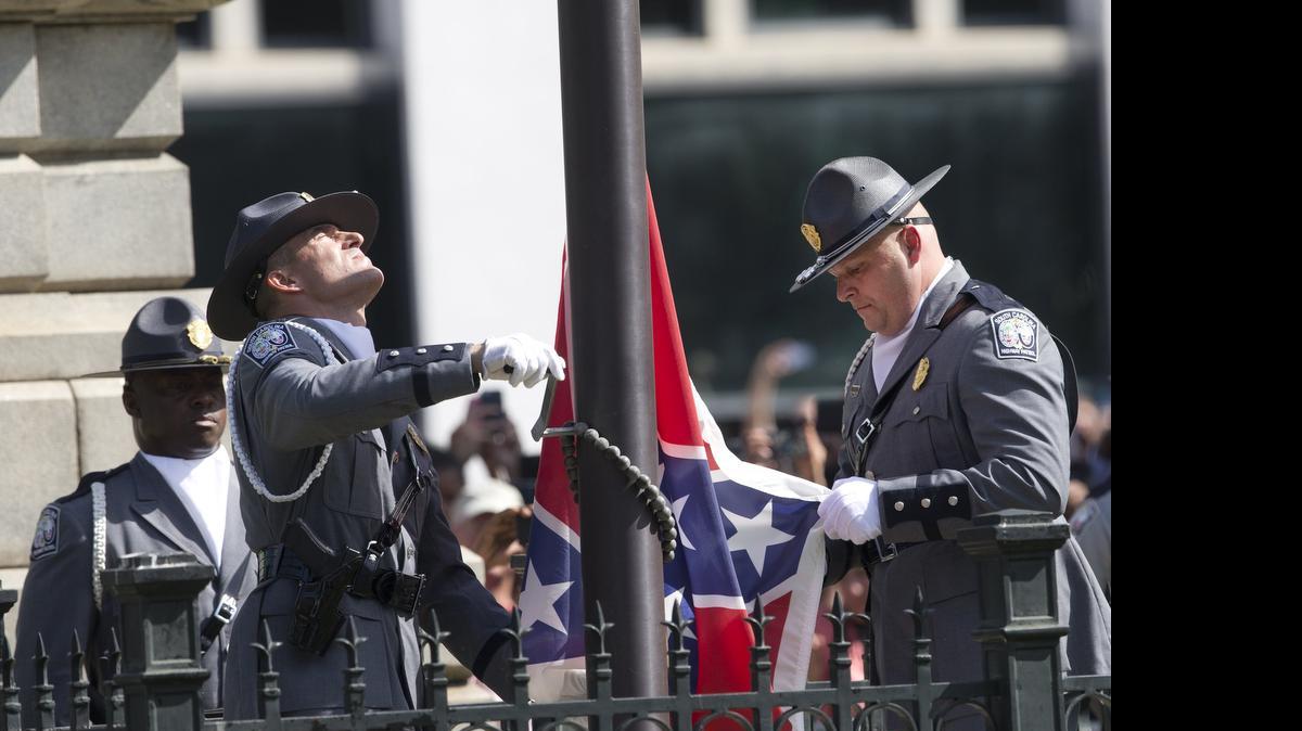 
An honor guard from the South Carolina Highway Patrol removes the Confederate battle flag from the Capitol grounds Friday, July 10, 2015, in Columbia. 
