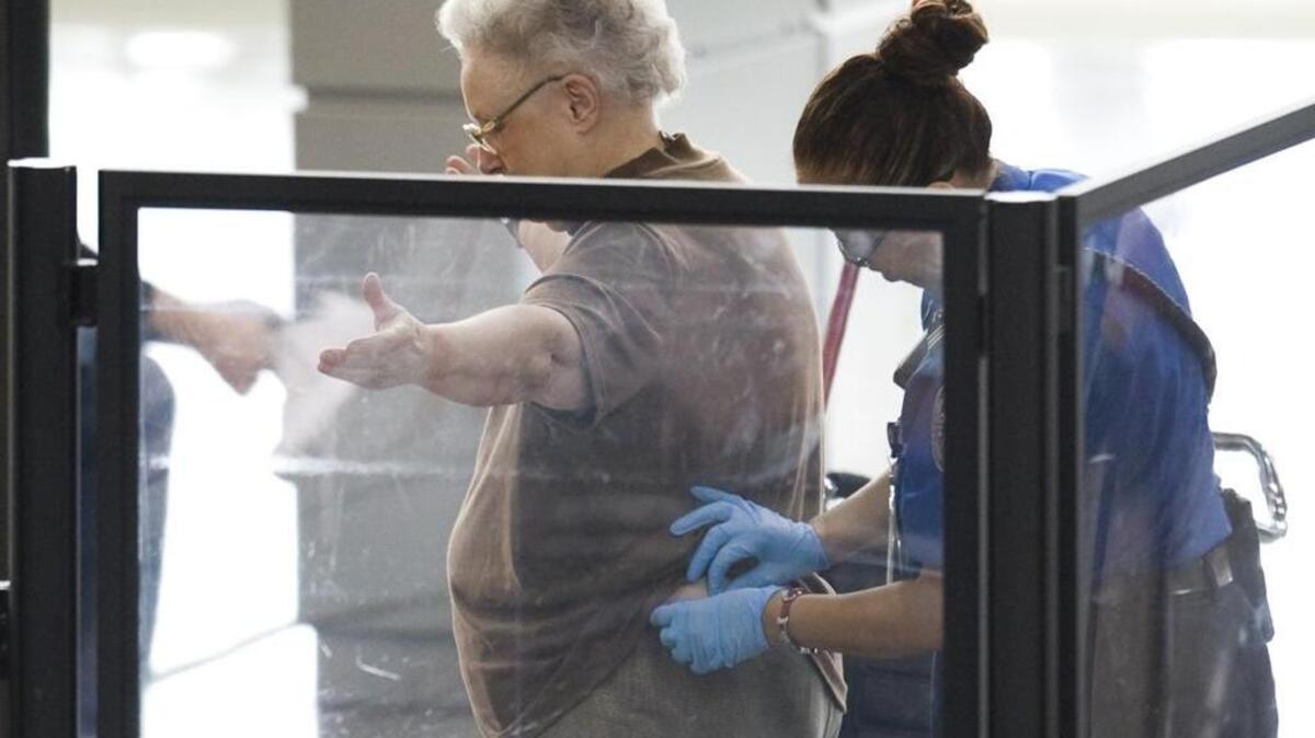 A woman gets a pat-down from a TSA agent.