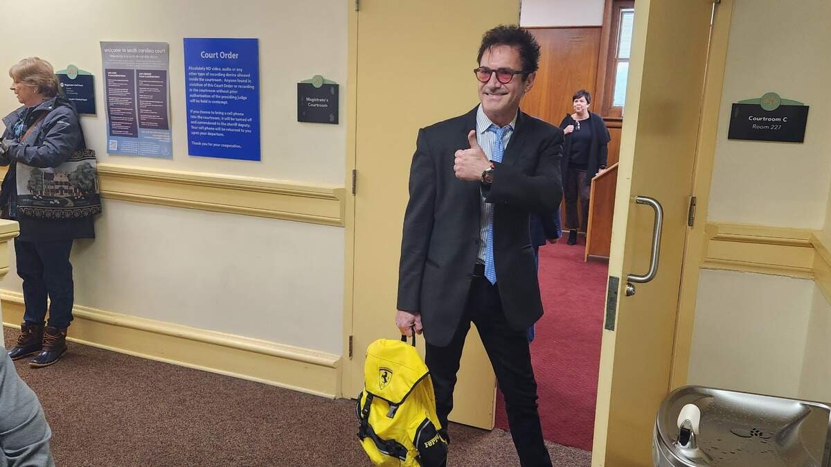 Former Horry County GOP chairman Roger Slagle signals to supporters ahead of a Jan. 30, 2023 trial over possession of property owned by the state party