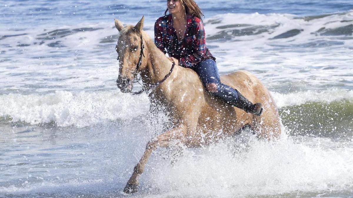 Madison Sitzler of Murrells Inlet rides her horse "Dollar" in the surf at Lakewood Campground.