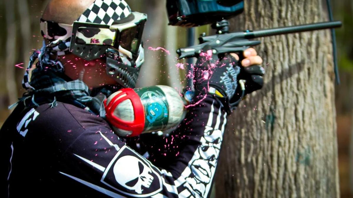 A North Carolina man takes enemy fire on the thumb as he fires from behind a tree during a 2011 game at Adventure Beach Paintball in Little River. Another paintball facility could open this spring or summer in Socastee if a rezoning request is approved. Photo by Matt Silfer For The Sun News