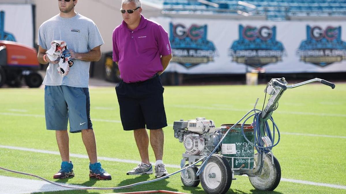 Horry-Georgetown Technical College Sports Turf Management student Scott Condon takes a break from helping with the field painting while he talks with his Professor Charles Granger Thursday morning. Granger brought a group of students to Jacksonville to help out the SMG grounds crew prepare EverBank Field for the weekend's Georgia/Florida game to give them real world experience.