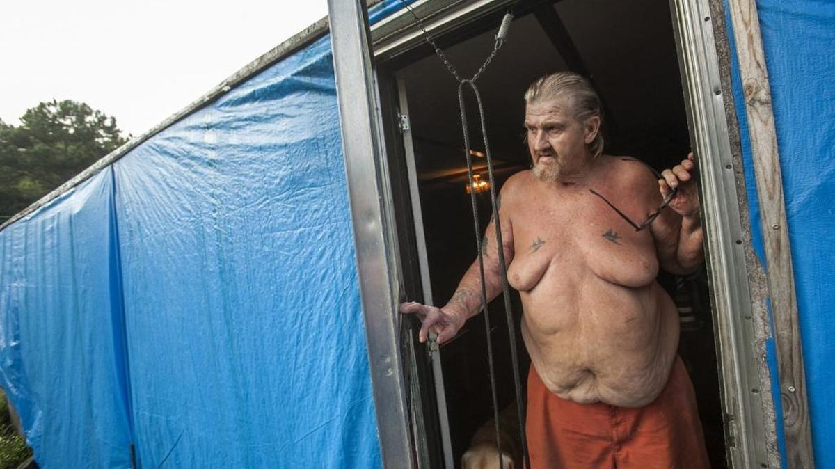 Stanley Tryskuc stands in front of his water damaged home in Longs. The 74-year-old retired Navy veteran's home is one of more than 100 still damaged in Horry County after a one-two punch of torrential rain and wind led to a state of emergency last October. Tryskuc said a church group helped wrap his home in plastic tarps after the walls began disintegrating under the heavy rains, but that he has received no further assistance and that FEMA has refused to help. Sept. 29, 2016