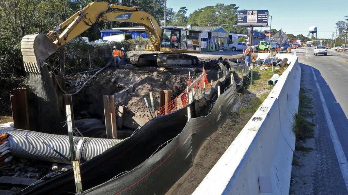 Crews work on extending a culvert beneath Third Avenue South near Withers Swash Park in Myrtle Beach on Wednesday.
