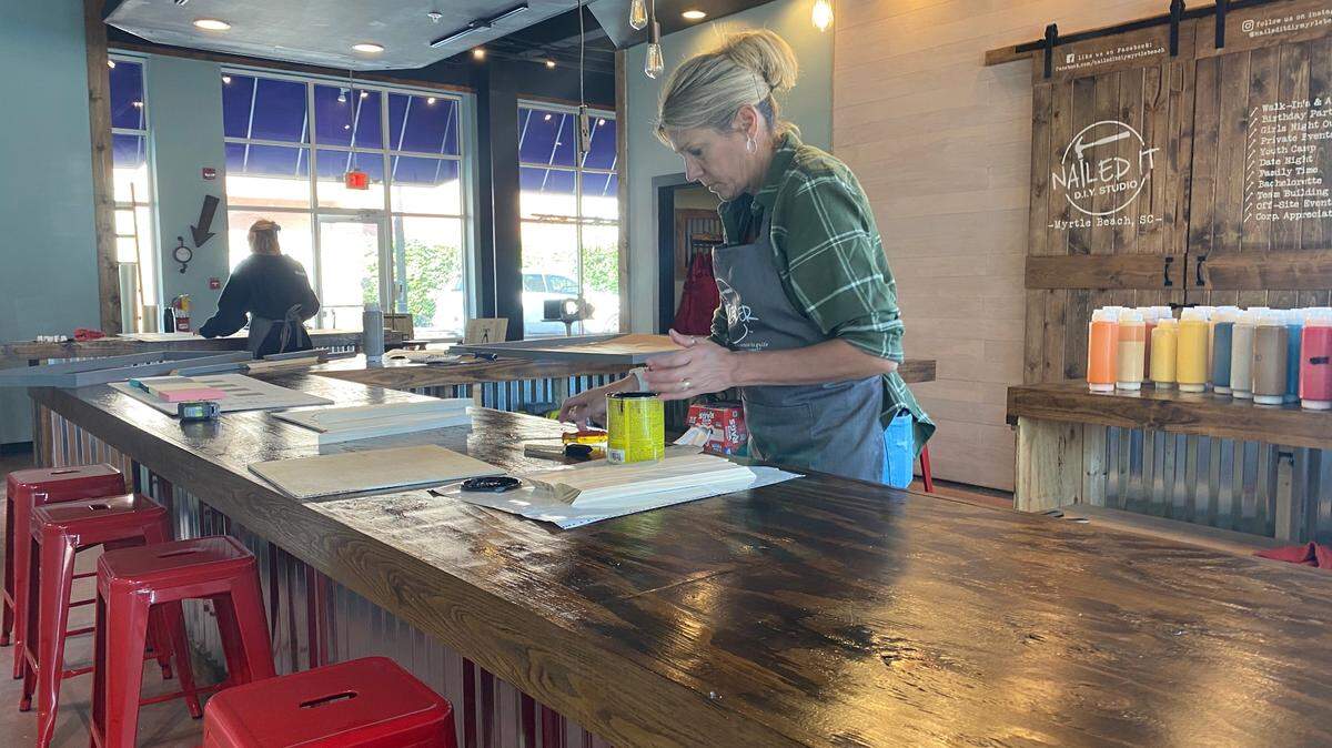 Julie Evans, owner of Nailed It DIY Studio, worked on setting up the studio on Tuesday morning. The studio will be open in the Market Common area on October 13, 2022.