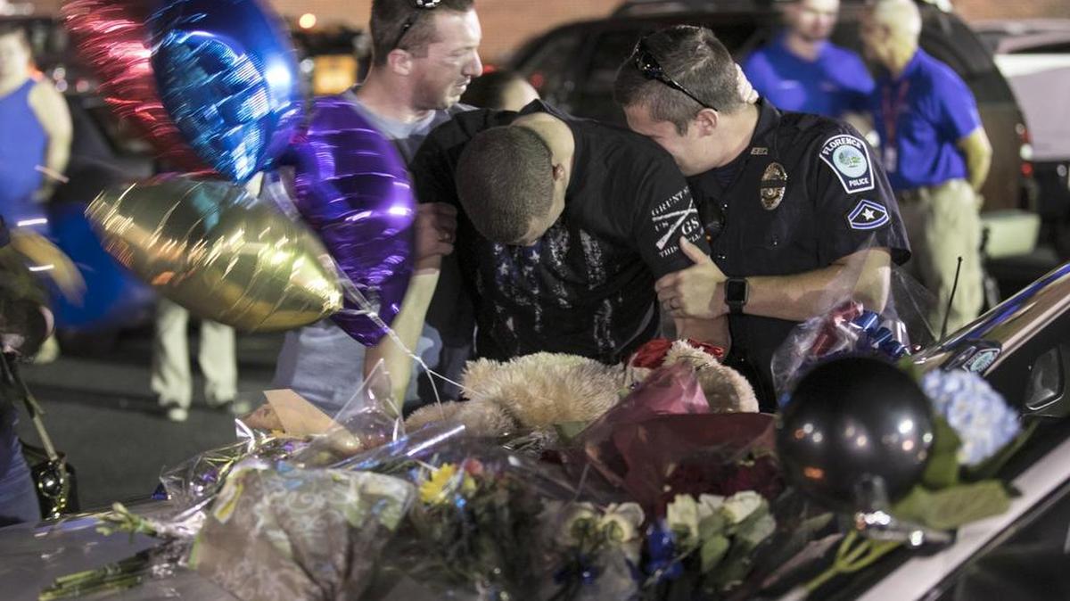 Florence police officers mourn at a makeshift memorial following a candlelight vigil for Sgt. Terrence Carraway who was killed in the line of duty on Wednesday. Florence, SC. Thursday, Oct. 4, 2018