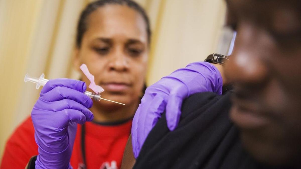 Todd Nelson, right, gets a flu shot from nurse Nicole Simpson at the Salvation Army in Atlanta on Wednesday.
