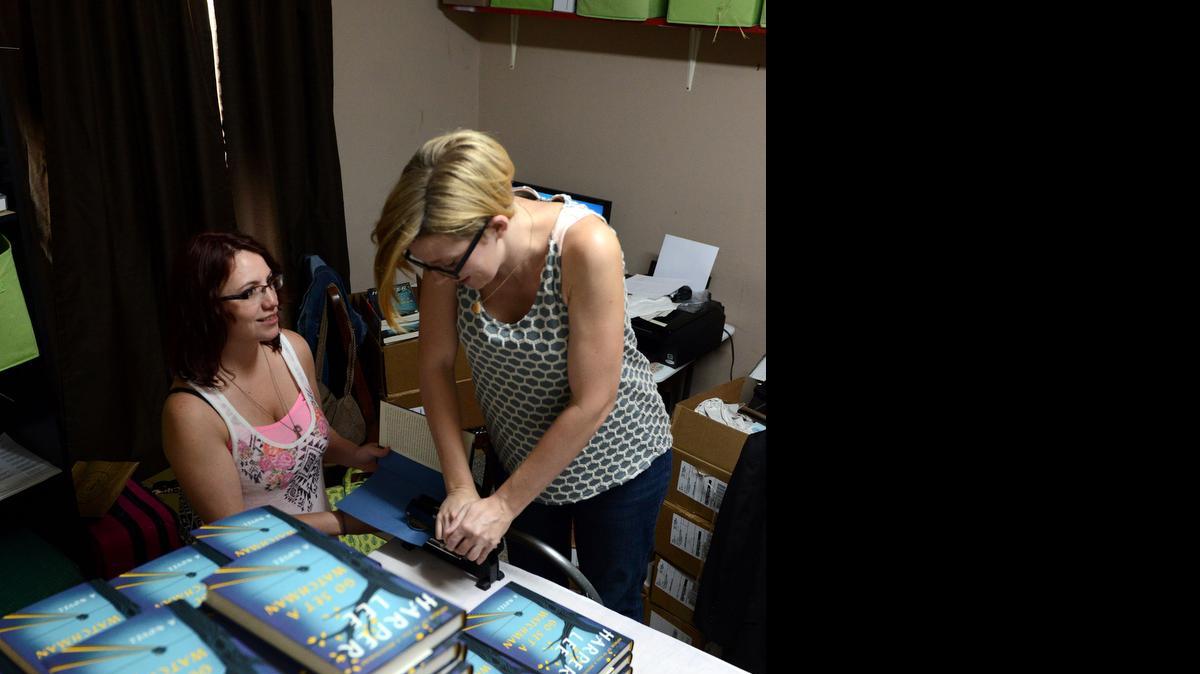 
Jane MacAdam, far left, and Ginny Bordeaux emboss copies of "Go Set a Watchman" in Ol' Curiosities & Book Shoppe on the book's release date in the hometown of "To Kill a Mockingbird" author Harper Lee, in Monroeville, Ala., Tuesday, July 14, 2015. 
