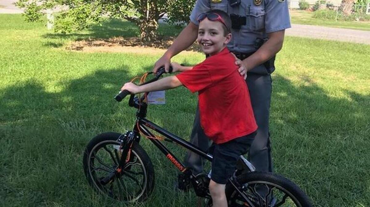 Officer Kevin Cast and Aiden Crawford posing with Aiden’s new bike.