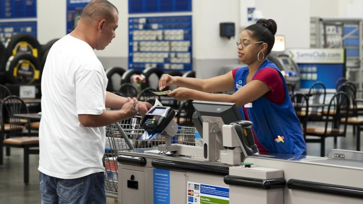 Conquisia Tyler, right, gives change to a customer at Sam's Club in Bentonville, Ark.