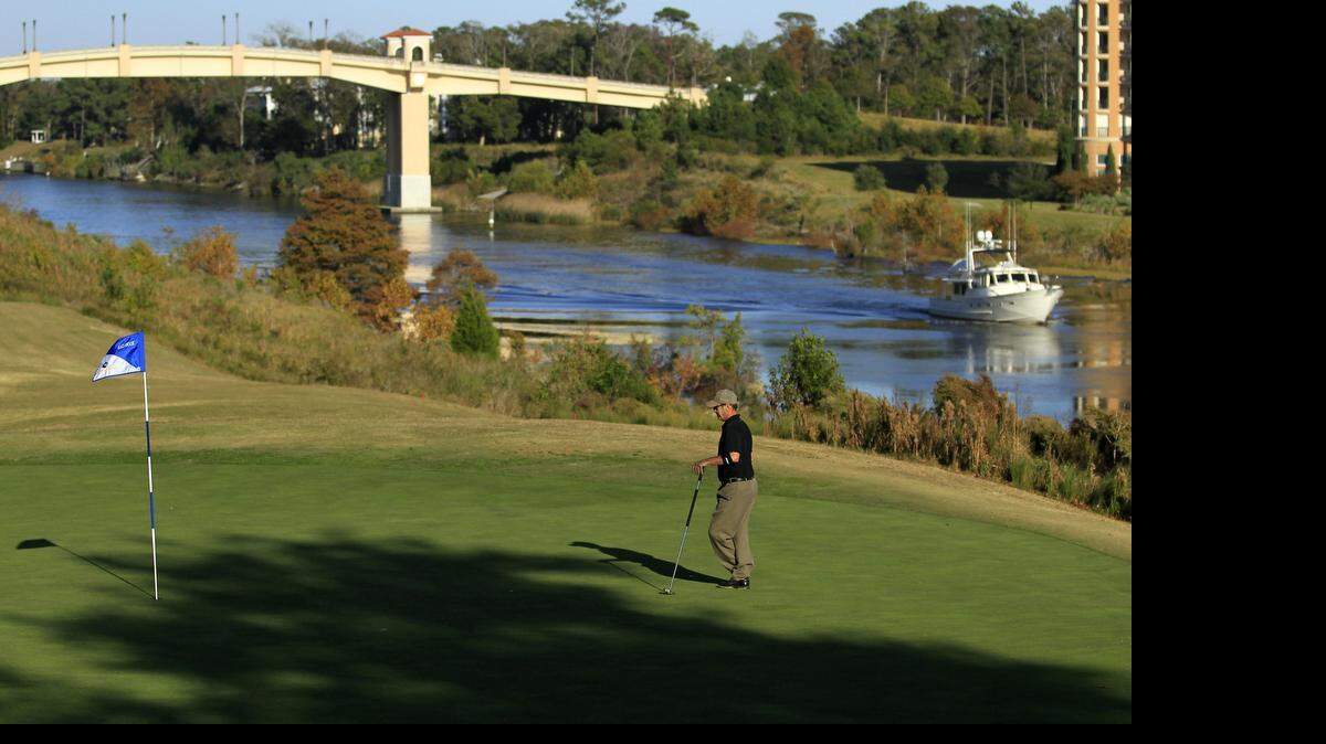 
A Golfer lines up a putt on the ninth hole which plays along the Intracoastal Waterway at the Grande Dunes Resort Course.
