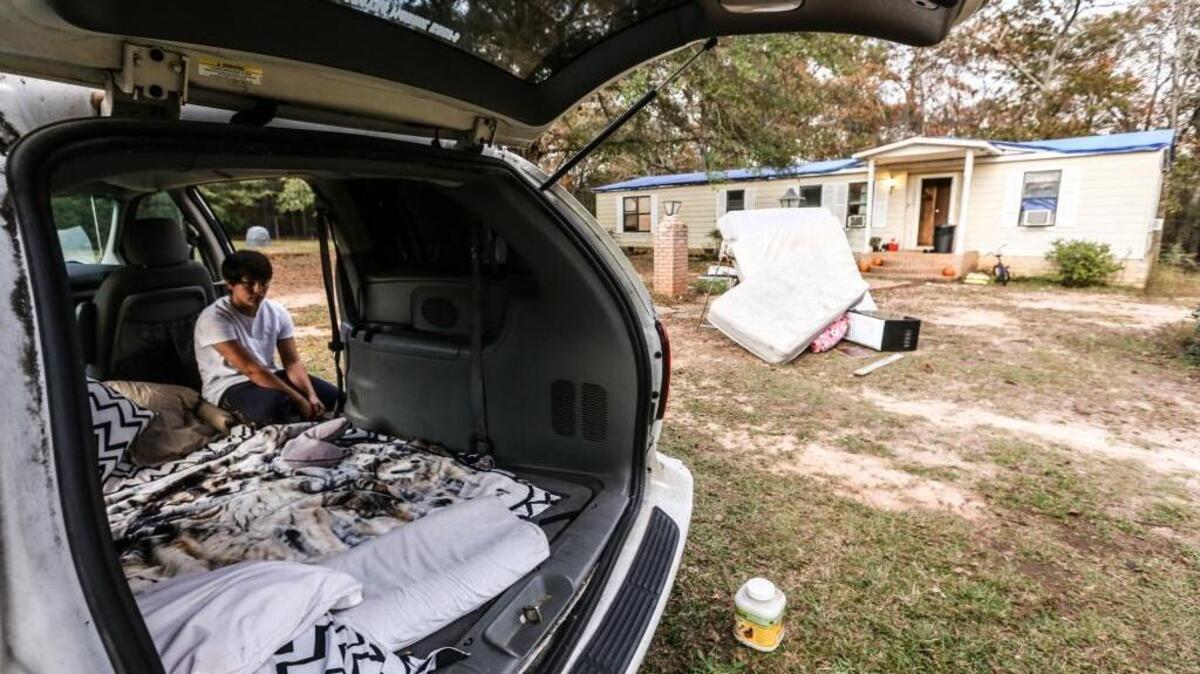 Journey Ramirez, 13, sits in the back of her mom's mini-van she and her 3 sibilings stayed in after thier home inundated with mold resulting from October's rainstorm. Her mother, Manndy McKenney, a veteran of both the Army and Marines, and thier home was unsalvageable because her roof could not sustain the more than 20-inches of rain that flooded South Carolina. Manndy and her four children are now homeless. FEMA would not provide her with aid because she has insurance, but her insurance company only gave her enough money to replace a few shingles on her roof and a fence in the backyard. Home inspectors came to her home and told her it had to be demolished because of mold that grew in the wake of the storm.