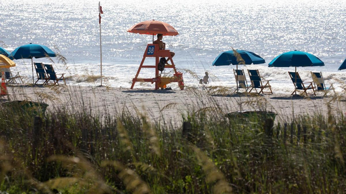 A Myrtle Beach lifeguard watches a few swimmers on a July morning before beaches are packed with tourists. July 19, 2022.