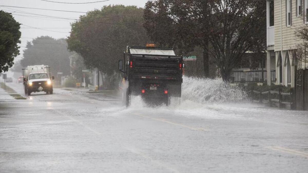 Utility trucks drive through flood waters on Duffy Street in North Myrtle Beach.