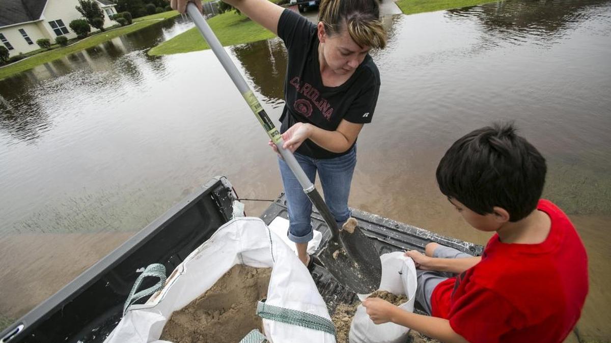
Zebeth Fowler and Gabriel Hines, age 11, fill sand bags in hopes of protecting a home in The Retreat subdivision in Little River. 
