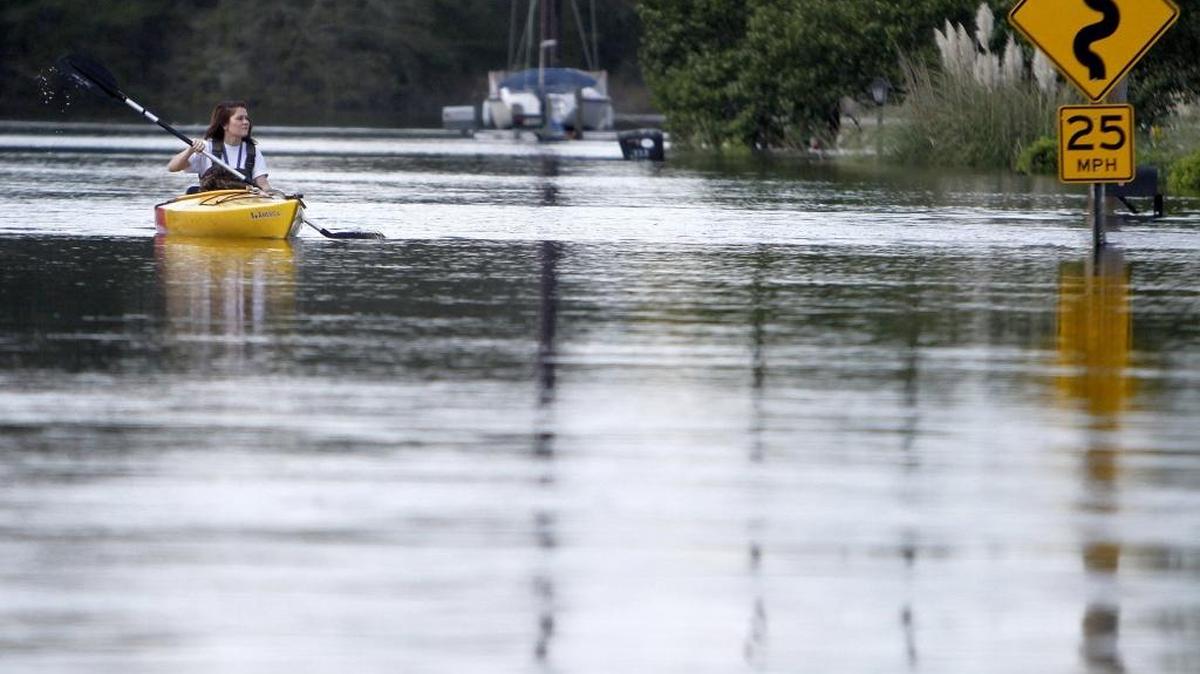 A woman paddles from her house to the landing at Savannah Bluff in Conway on Oct. 8. The record flooding left many around South Carolina in dire need.