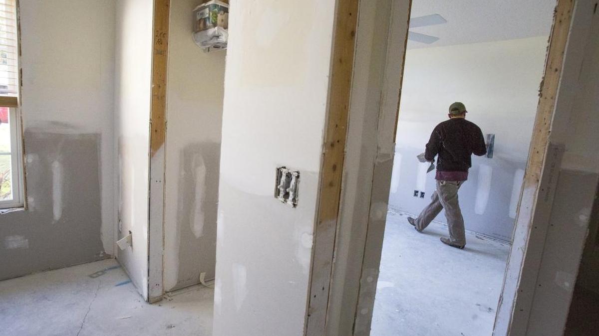 Shane Roach finishes dry wall on Betty Skeen's home that was damaged by two feet of floodwater in October. Skeen, 79, had to move out of her home so the interior could be gutted and renovated, but she hopes to be home for Christmas.