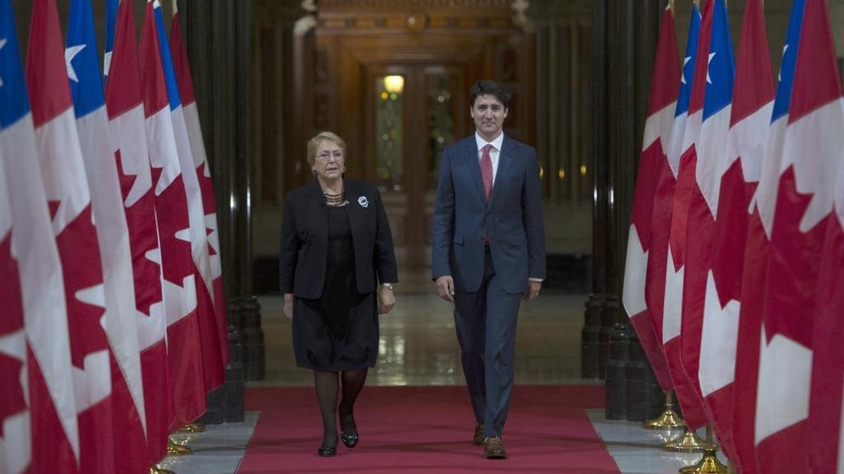 Canadian Prime Minister Justin Trudeau and Chilean President Michelle Bachelet walk through the Hall of Honor as they make their way to a signing ceremony and joint news conference on Parliament Hill in Ottawa on Monday.