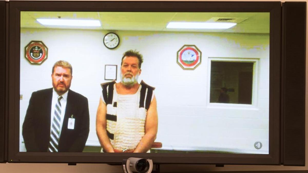 Colorado Springs Planned Parenthood shooting suspect Robert Dear, right, appears via video hearing during his first court appearance, where he was told he faces first degree murder charges on Monday. At left is public defender Dan King.
