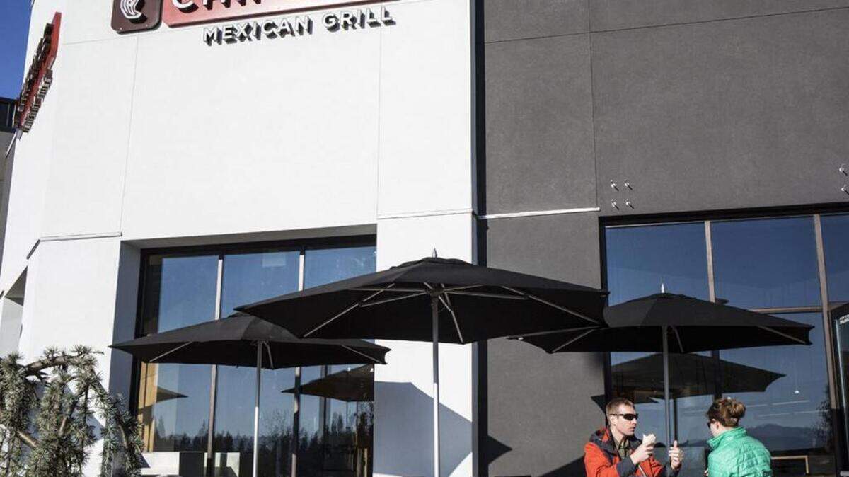 Customers sit at Chipotle Mexican Grill in Bellingham, Wash., during the restaurant's grand opening Nov. 15, 2014, at Bellis Fair Mall. Chipotle closed its restaurants in Washington and Oregon due to an E. coli outbreak that may be linked to Chipotle restaurants.