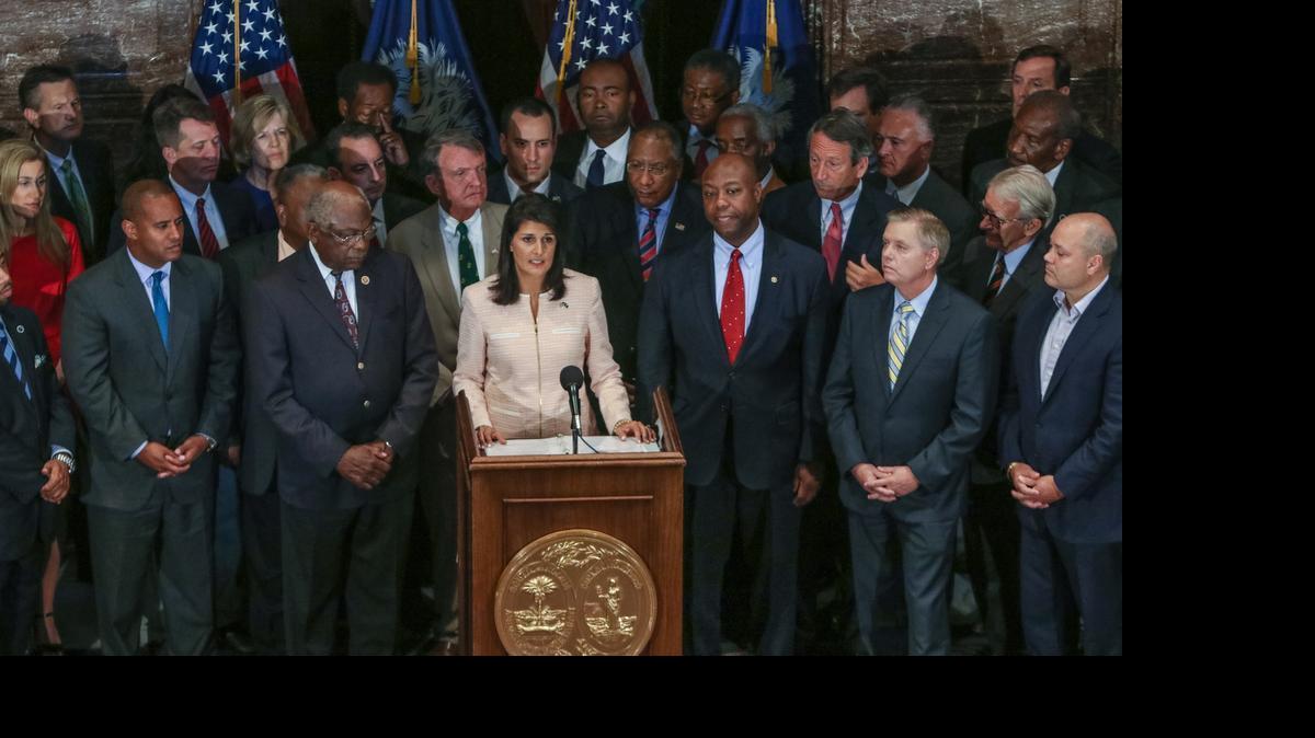 
South Carolina Gov. Nikki Haley, center, calls for legislators to remove the Confederate flag from the Statehouse grounds during a news conference in the South Carolina State House in Columbia, S.C., Monday, June 22, 2015. Those surrounding her as she spoke included state legislators of both parties. 

