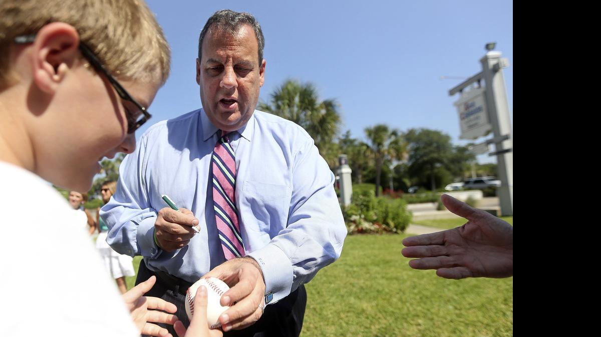 
Chris Christie, New Jersey governor and one of 16 Republican presidential candidates, signs a baseball for Austin Wolff, 11, of Waynesboro, Pa., at Sea Captain's House in Myrtle Beach on Tuesday, July 21, 2015.
