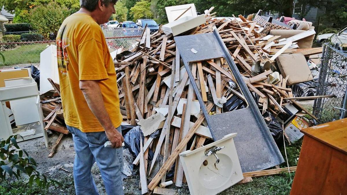 
State newspaper reporter Jeff Wilkinson looks at some of his flood damaged items from his home on Downing Street on Oct. 8. The home was overtaken by flood waters and Wilkinson and his girlfriend had to swim to safety.
