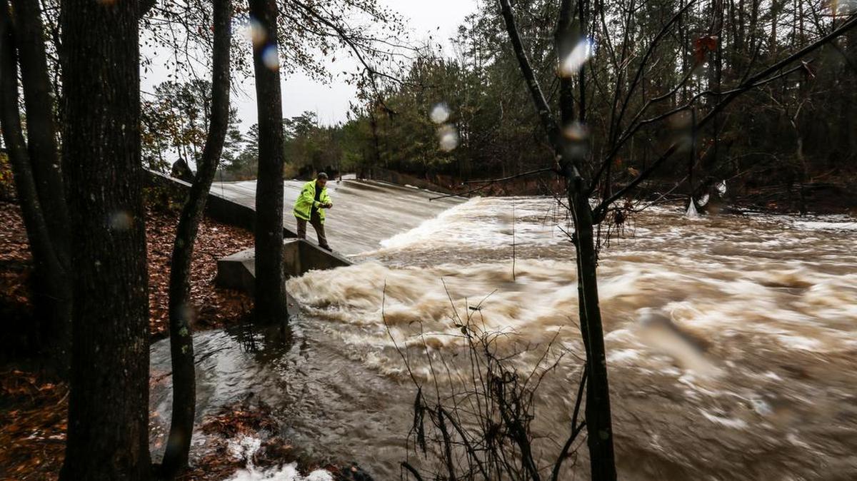 A DHEC dam inspector looks over a dam near Farrow Road in Northeast Columbia on December 23, 2015, after heavy rains filled the lake with water and caused it to spill over the top.