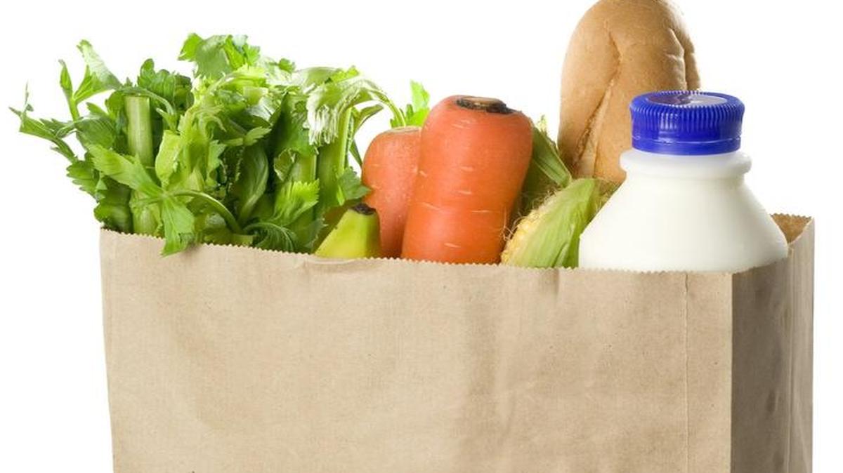 Paper bag full of groceries isolated on white background