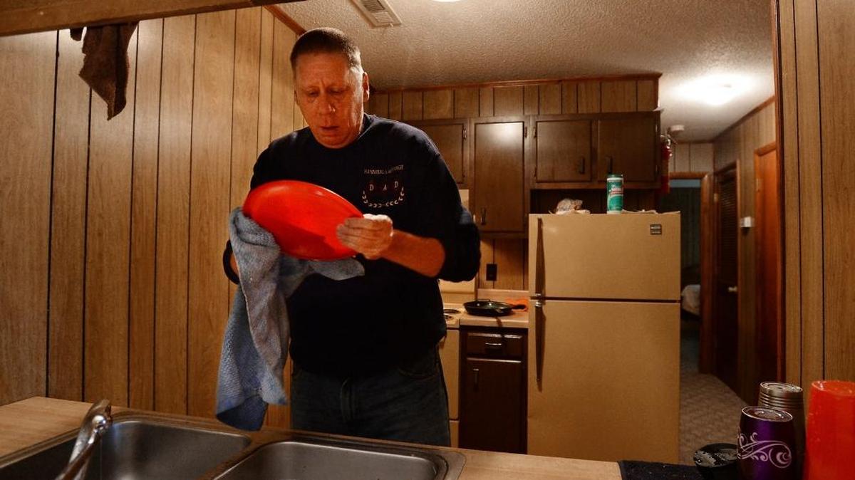 Military veteran Richard Pittman washes plastic plates in the kitchen of his new apartment in Fayetteville, N.C., earlier this month.