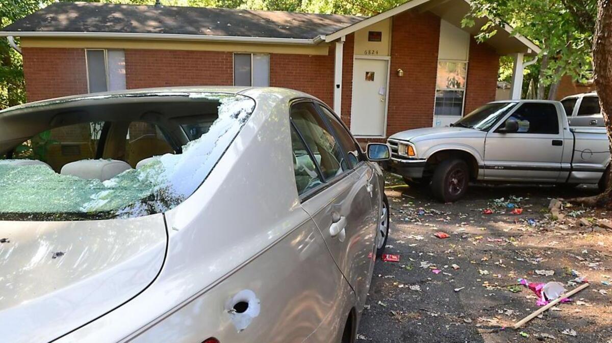 
A bullet-riddled car and candy spilled from a  piñata are visible outside a home on Fieldvale Place in southwest Charlotte on Sunday. A 7-year-old boy died after being shot during a party at the home.


