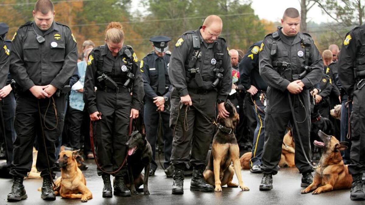 Richland County Sheriff's Department police officers bow their heads in prayer during a memorial service for K-9 officer Fargo at the Richland County Sheriff's Department Headquarters.
