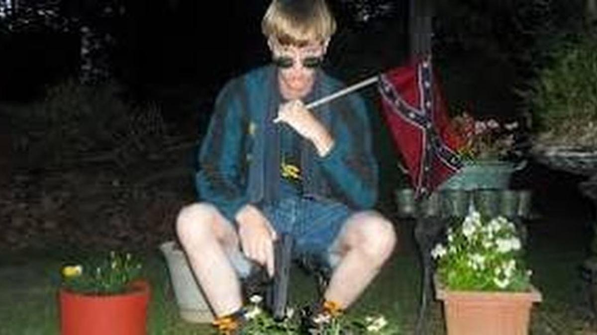 Dylann Roof poses with a Confederate flag and a gun.