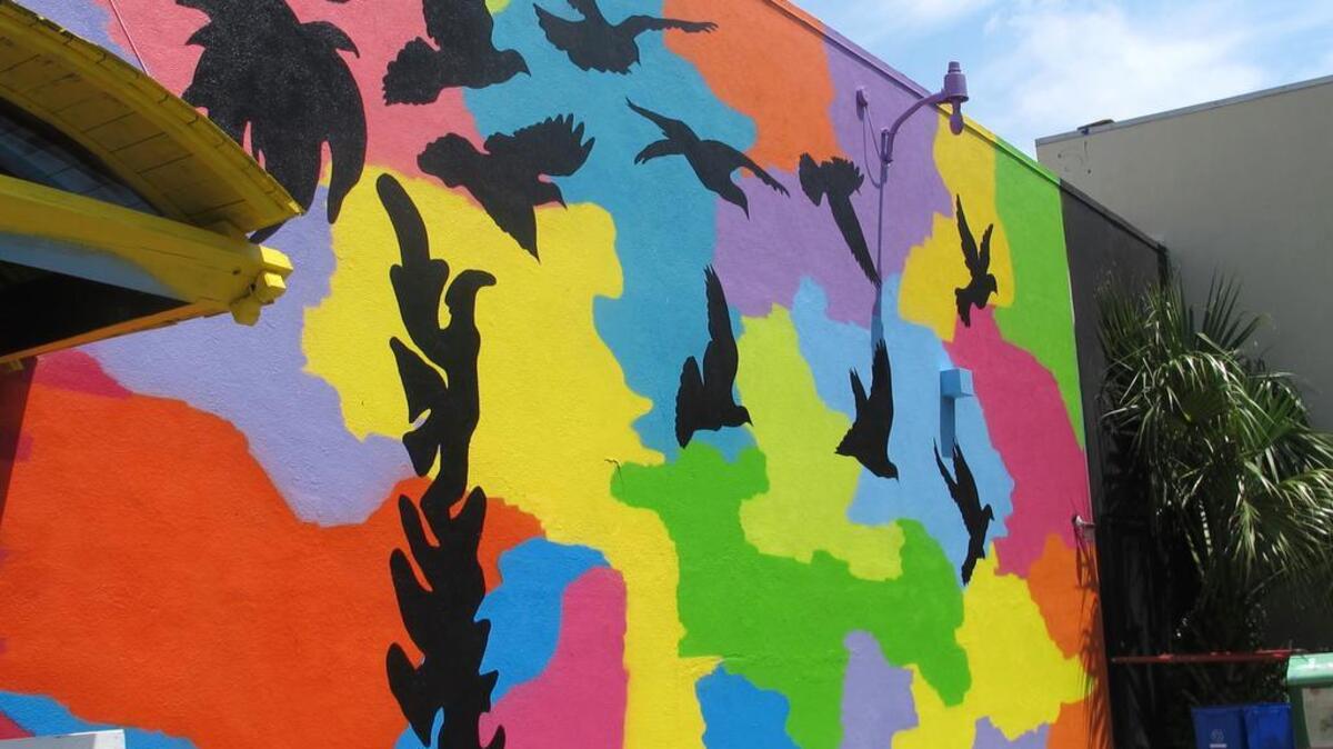 An image of a palmetto tree, a South Carolina state symbol, with doves ascending into the sky is seen on a mural honoring the victims of the June 2015 shootings at Emanuel AME Church in Charleston, S.C., on Friday, May 13, 2016. The mural was unveiled on the side of a building a few blocks from the church. It was created by artist Tripp Derrick Barnes to honor the nine shooting victims as the first anniversary of the slayings approaches. (AP Photo/Bruce Smith)